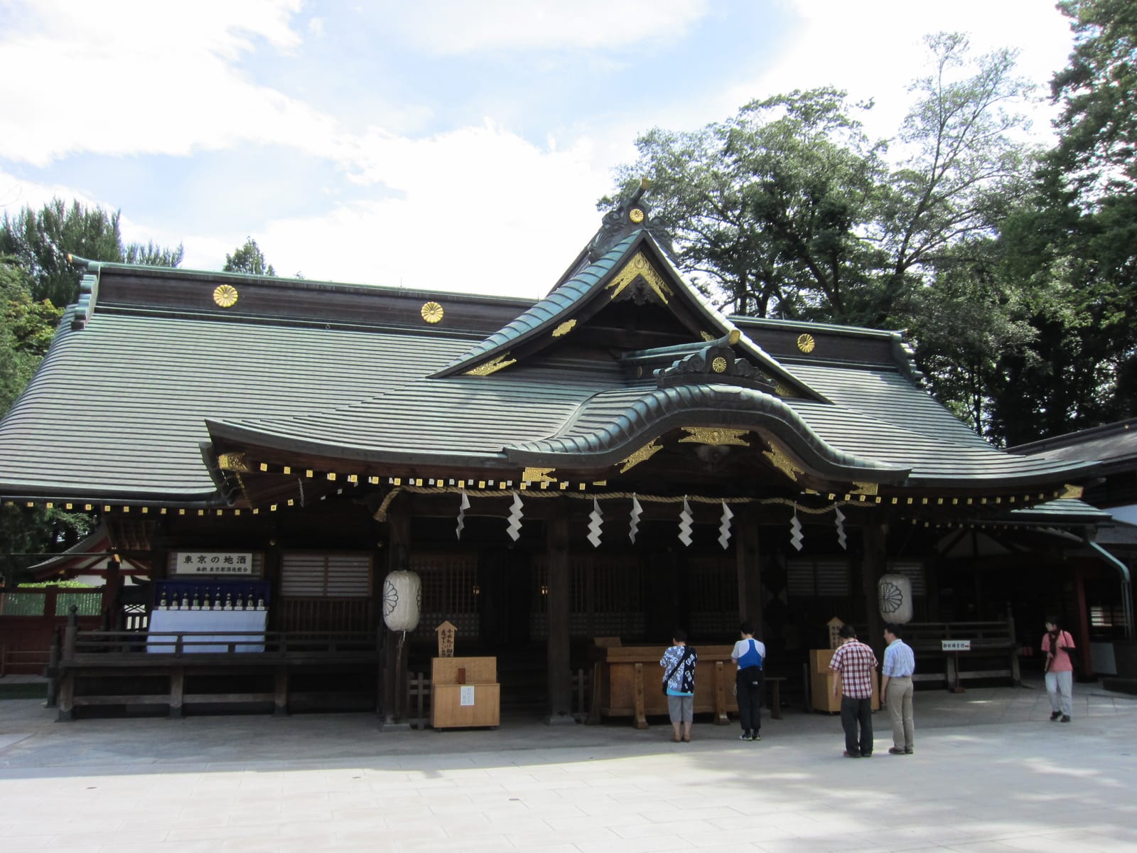 The prayer hall of Okunitama Shrine seen from the front of the stone-paved courtyard.