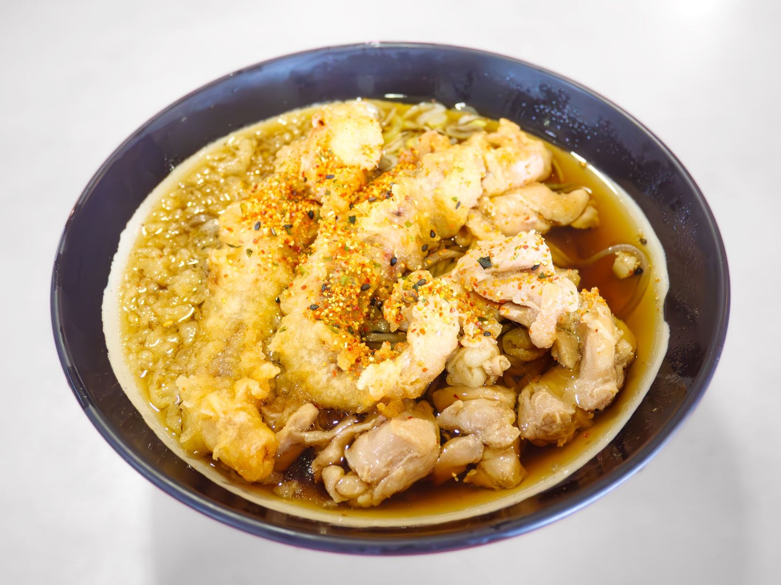 A bowl of chicken soba topped with squid tempura from a food stall at Tokyo Racecourse.