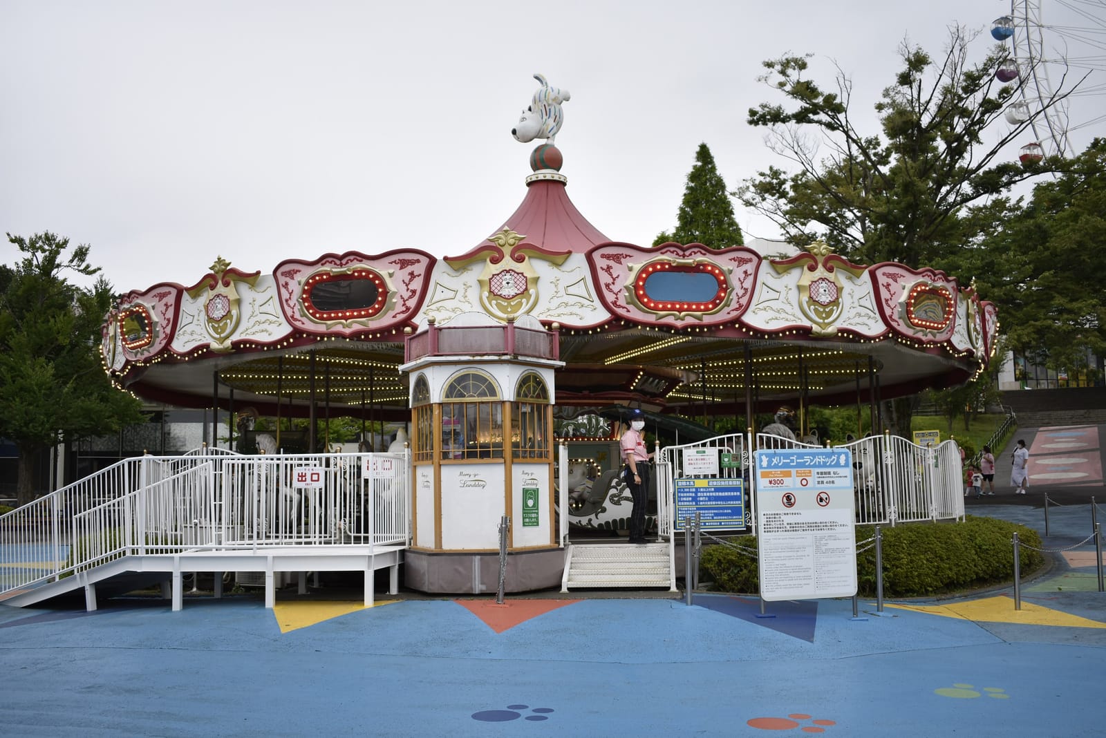 A quiet merry-go-round in Yomiuriland's children's area, with a ramp and fenced queue at the entrance.