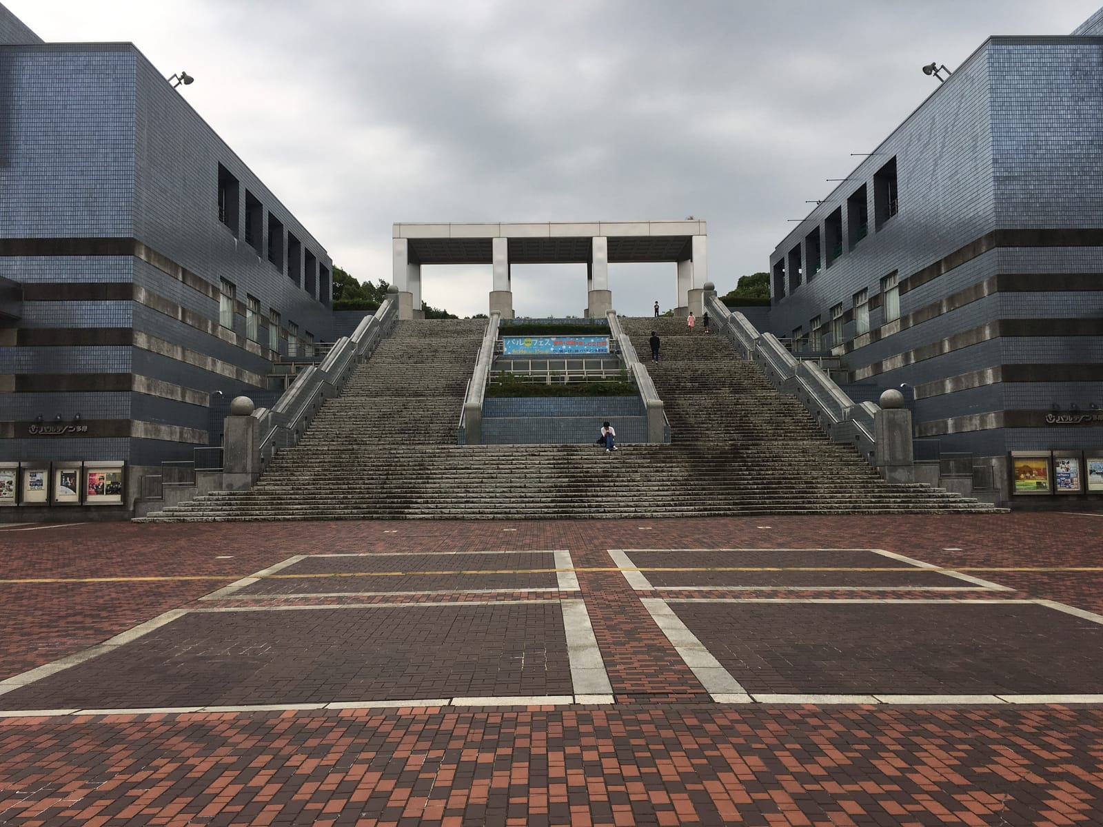 The brick plaza and grand staircase of Parthenon Tama, flanked by its two buildings