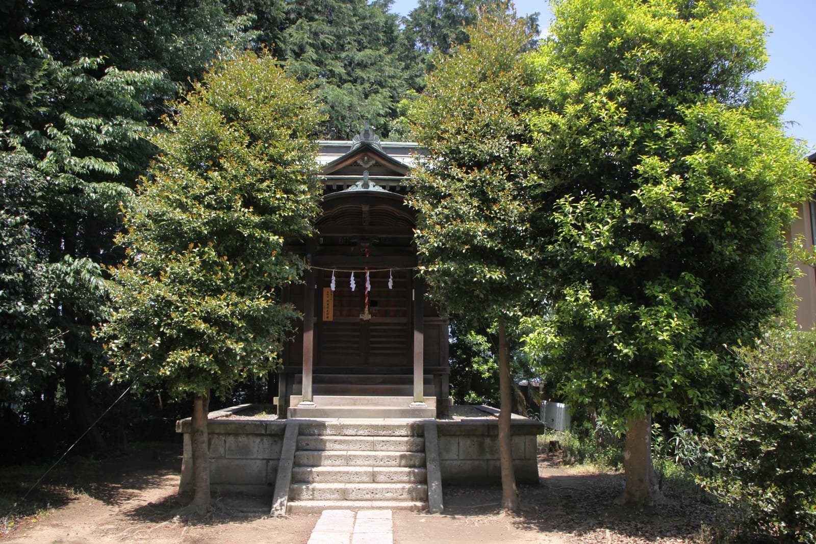 The small wooden hall of Konpira Shrine in Sakuragaoka, Tama, framed by green trees