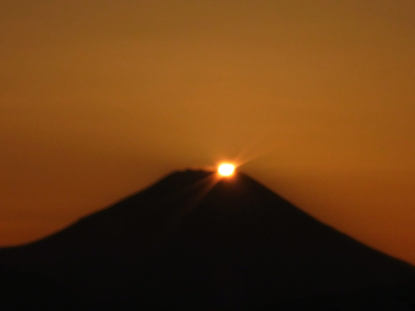 The sun setting exactly on the summit of Mt. Fuji (Diamond Fuji), seen from the top of Mt. Takao.